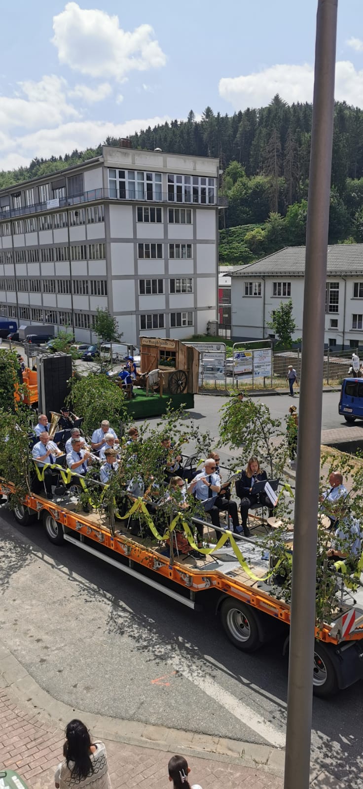 Die Feuerwehrkapelle spielt auf einem mit Birkenzweigen geschmückten Festwagen beim Umzug