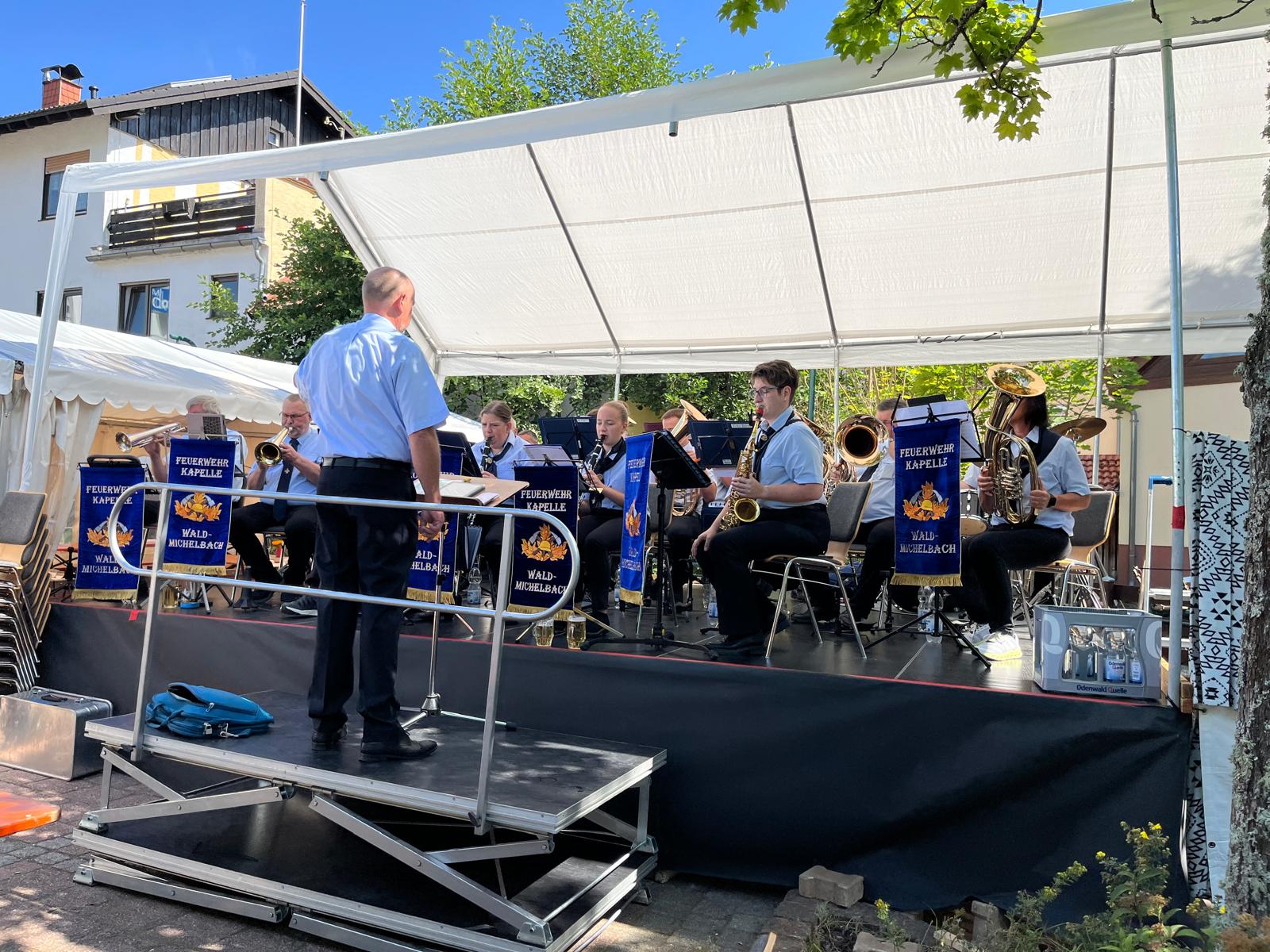 Auftritt unter weißem Pavillon bei Sonnenschein in hellblauen Hemden