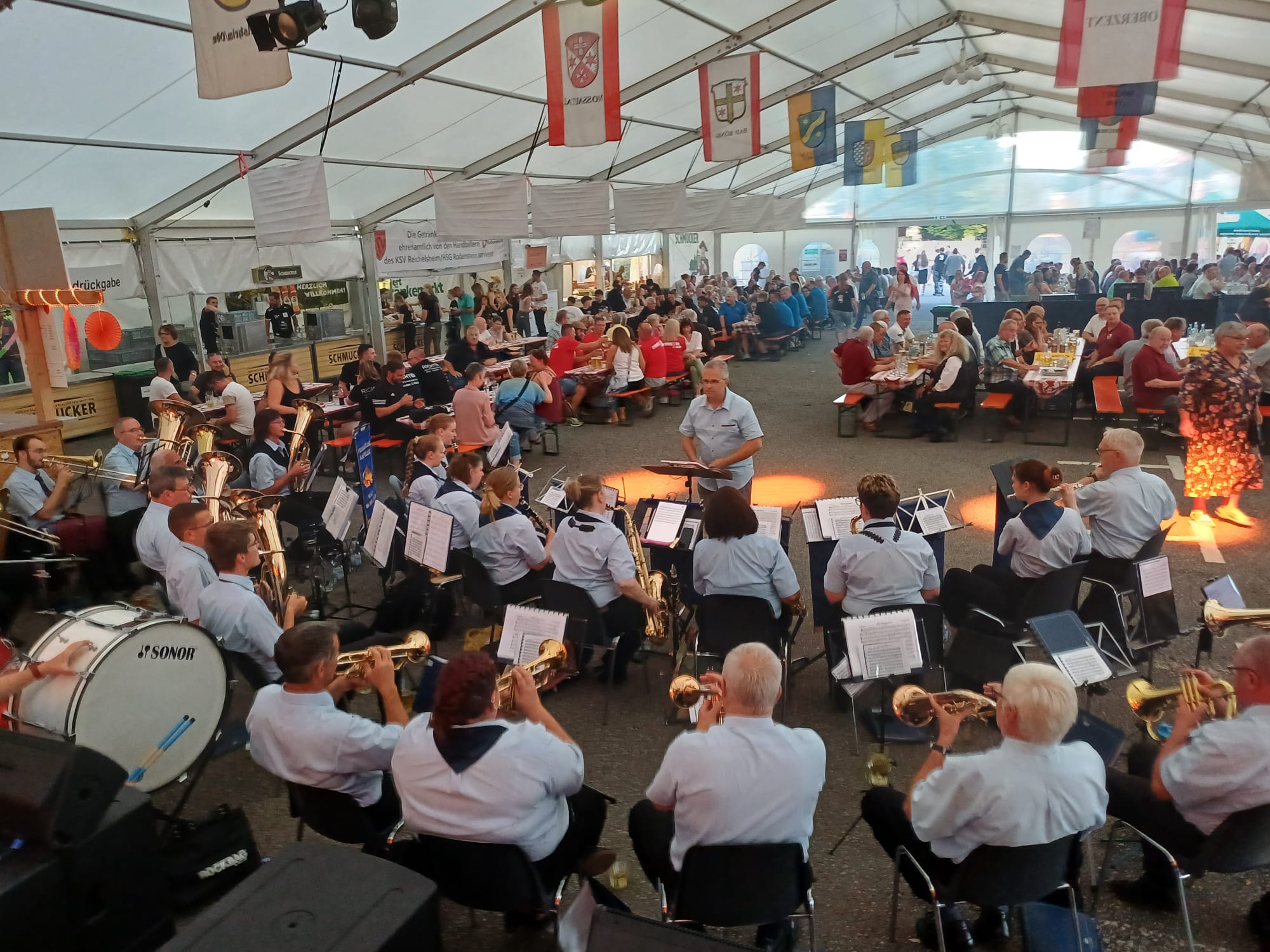 Abendkonzert der Feuerwehrkapelle im Festzelt mit oranger Bühnenbeleuchtung