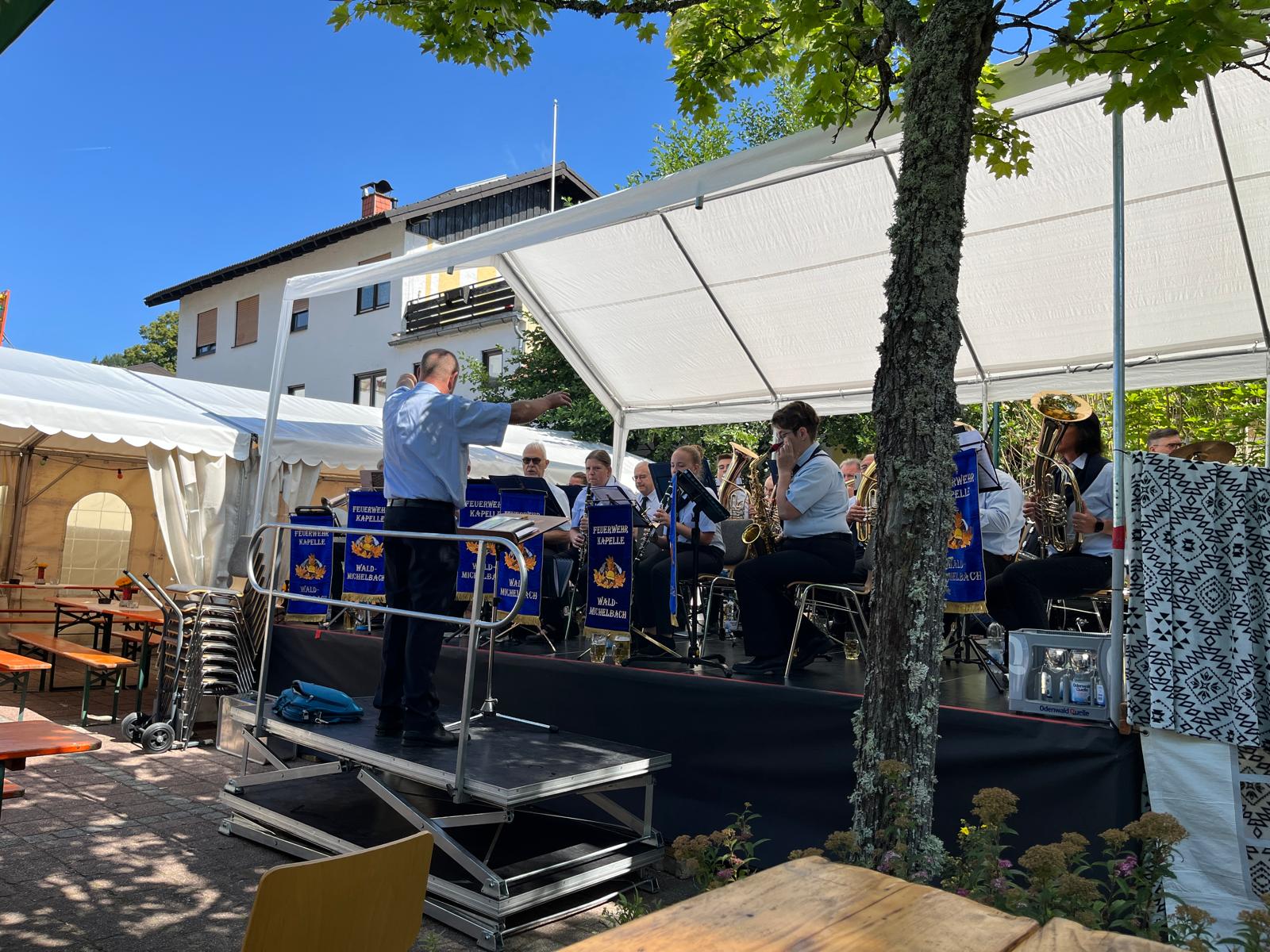 Auftritt der Kapelle unter weißem Pavillon mit Dirigent auf dem Podest