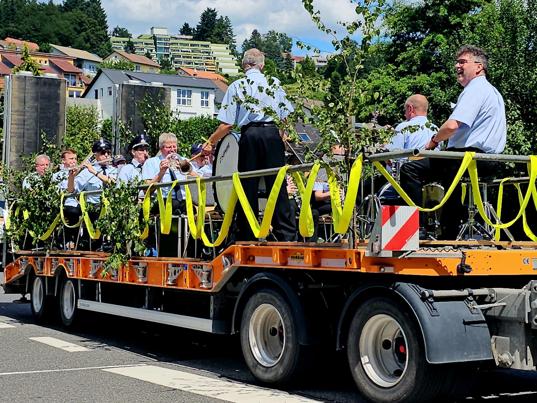 Die Feuerwehrkapelle beim Umzug auf dem orangen Tieflader
